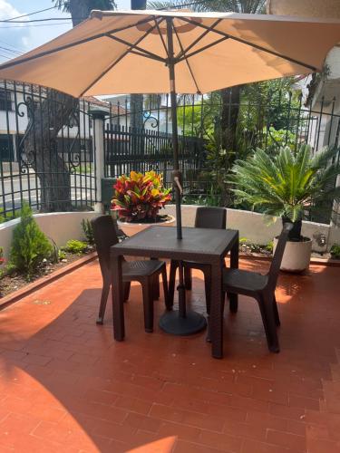 卡利CASA HOTEL FLOR DEL VALLE的庭院内桌椅和遮阳伞