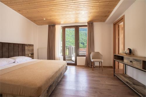 梅斯蒂亚Anne's Hotel in Mestia的一间卧室设有一张床和一个大窗户