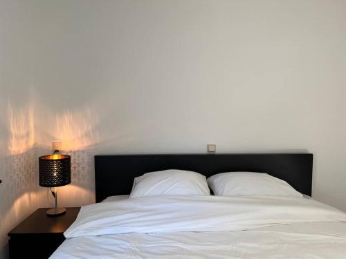 纽南The coffee Corner Nuenen/Eindhoven的一张带黑色床头板和灯的白色床