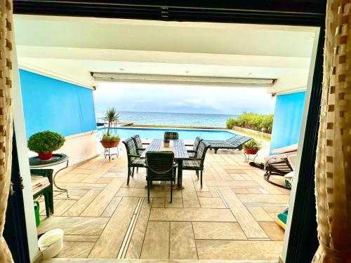 ArakhovítikaPool Beachouse With Stunning Views的一个带桌椅的庭院和大海