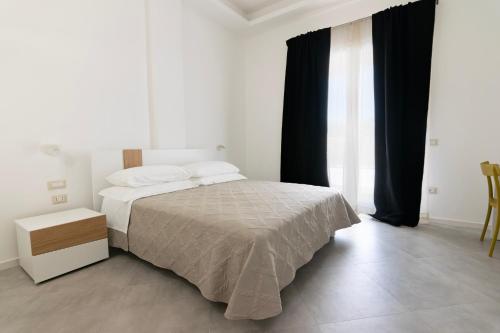 阿尔巴塔克斯Sa Pasadina的白色卧室配有床和黑色窗帘