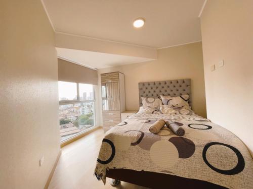 利马Habitación privada con hermosa vista de Barranco的一间卧室设有一张大床和大窗户