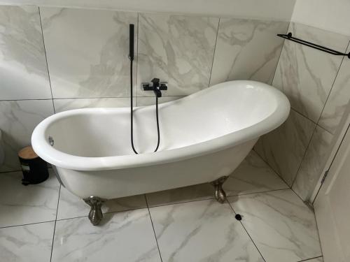 比勒陀利亚Soft petal的浴室铺有白色瓷砖,配有白色浴缸。