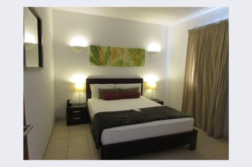圣玛丽亚Tortuga beach lovely 2 bed apartment and gardens的一间卧室配有床和两盏灯