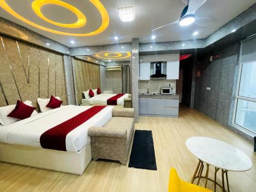 勒克瑙Golden Penthouse - Couple Friendly - DLF My pad, Gomtinagar, Lucknow的一间卧室配有一张床铺和一张桌子,还设有一间厨房