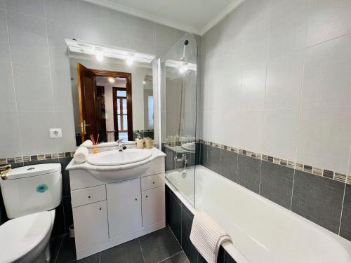 拉马莱斯德拉维克托里亚Excelente apartamento con garaje y piscina的一间带水槽、浴缸和卫生间的浴室