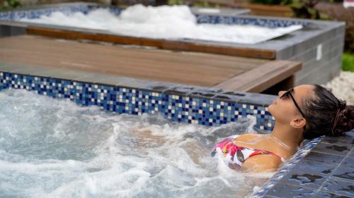 帕拉马里博Torarica Resort的游泳池里按摩浴缸里的女人