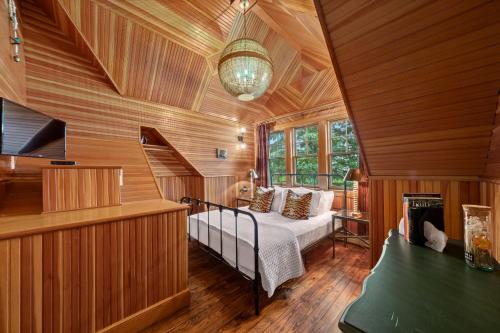 TannersvilleHotel Mountain Brook的卧室配有一张床铺,位于带木墙的房间内