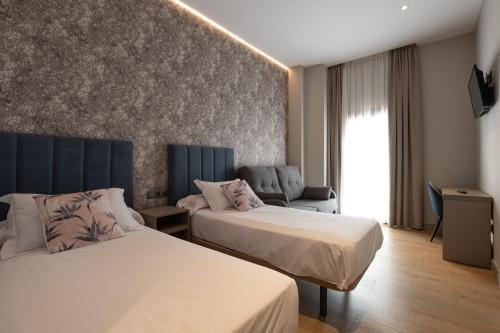 梅里达Hotel Aldama的酒店客房,设有两张床和一张沙发