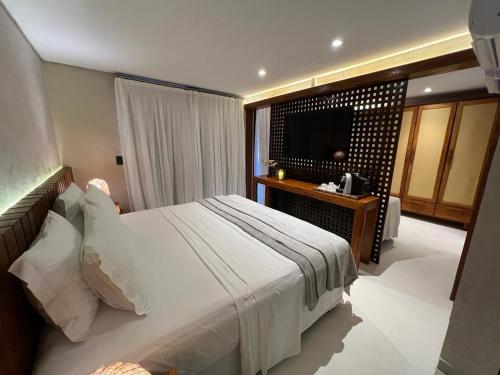 费尔南多 - 迪诺罗尼亚Pousada Naonda的一间卧室配有一张大床和电视