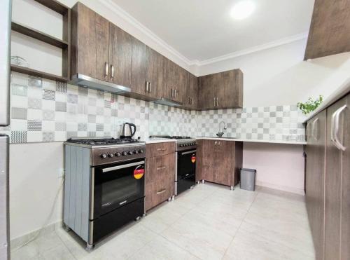 科布列季Elgabi Hotel Kobuleti的厨房配有木制橱柜和黑炉。