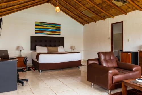 上钦查Qala Hotels & Resorts的一间卧室配有一张床、一张桌子和一把椅子