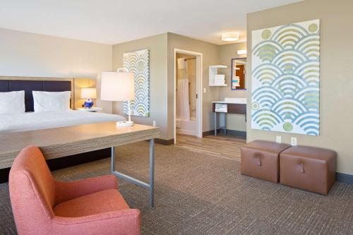 瓦拉瓦拉Hampton Inn & Suites by Hilton Walla Walla的一间卧室配有一张床、一张桌子和一把椅子
