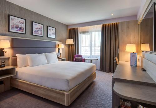 都柏林Hilton Garden Inn Dublin City Centre的配有一张床和一张书桌的酒店客房