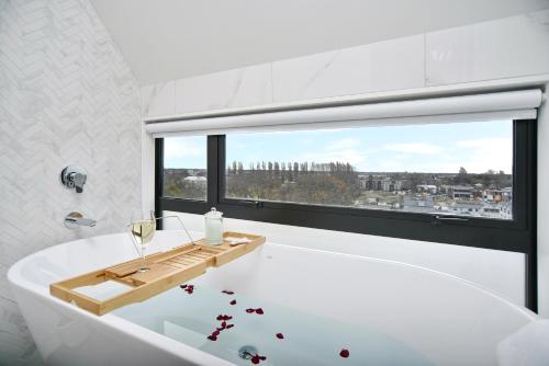 基督城Latimer Loft - Christchurch Holiday Homes的白色的浴室设有浴缸和窗户。