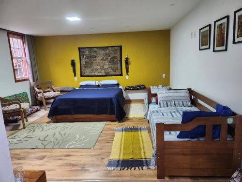 欧鲁普雷图Solar dos Reis Apartamento Topázio的一间卧室设有两张床和黄色的墙壁