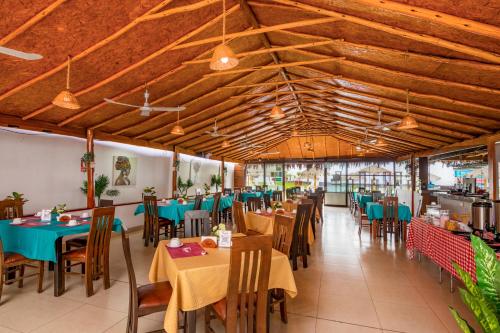 上钦查Qala Hotels & Resorts的用餐室设有桌椅和木制天花板