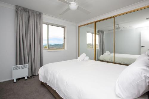 塔姆沃思Hillvue Lodge的卧室配有一张白色大床和镜子