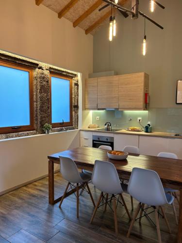 吉马良斯Villa Margaridi的厨房配有木桌和椅子