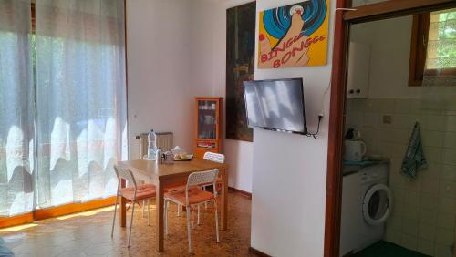 瓦拉泽Casa con giardino: Varazze的厨房配有桌子,墙上配有电视