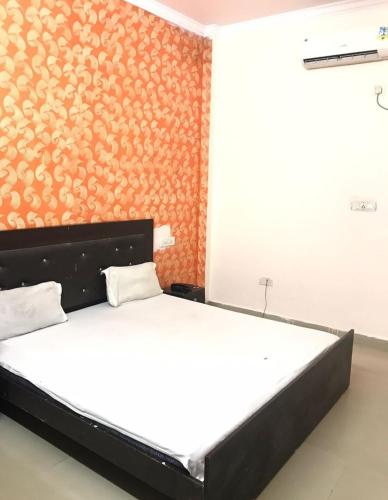 钱德加尔Hotel Jeet Lodge的一间卧室配有一张橙色墙壁的床