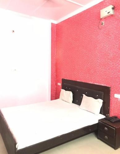 钱德加尔Hotel Jeet Lodge的一间卧室设有一张床和红色的墙壁