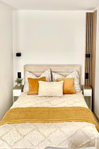 厄尔科Studio 2 Apartment的一张配有橙色和白色枕头的大床