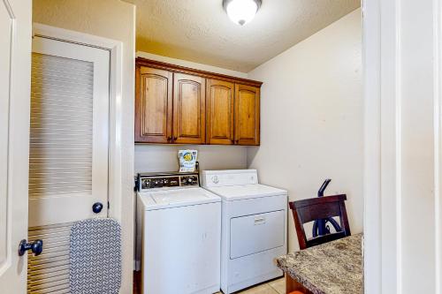 雪松城Cedar Park Oasis的洗衣房配有洗衣机和烘干机以及木制橱柜。