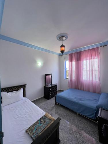 舍夫沙万Casa chaara的一间卧室设有两张床和窗户。