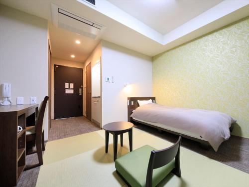 Hotel Futabanomori的卧室配有一张床和一张桌子及椅子
