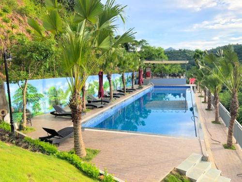 和平BlueHome Villa的一座棕榈树游泳池毗邻度假酒店