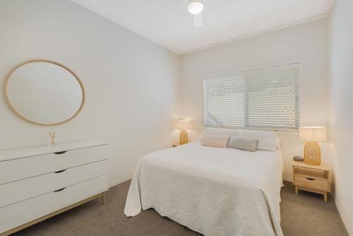 黄金海岸Skyline Apartments Unit 5的白色卧室配有床和镜子