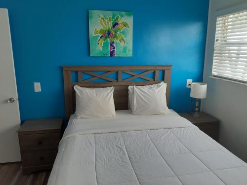 圣徒皮特海滩Sandalwood Beach Resort的一间卧室配有一张蓝色墙壁的床