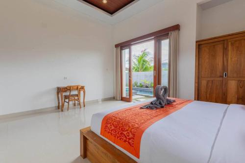 乌布New Private Pool Villa - Villa Dhea Ubud的一间卧室配有一张床、一张桌子和一个窗户。