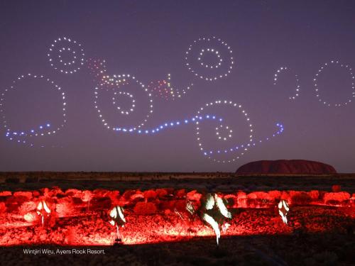 艾尔斯岩西洋鸵鸟酒店的一群人晚上在火堆旁跳舞