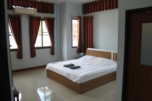 班佩Naluemon Village FH 3-4的一间卧室配有一张带白色床单和窗户的床。
