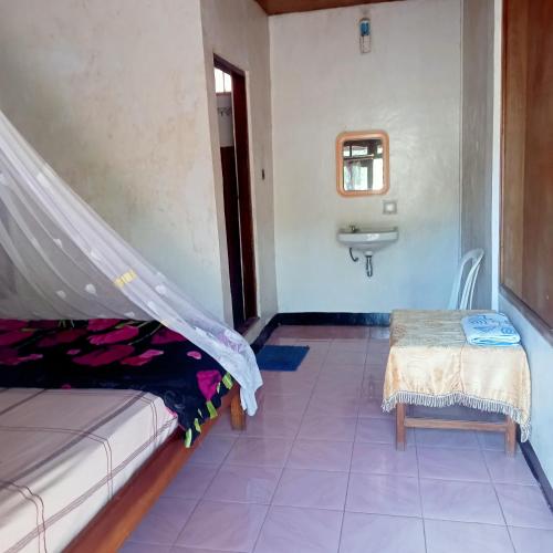 克里穆图WATUGANA BUNGALOW KELIMUTU的客房设有床、水槽和桌子。