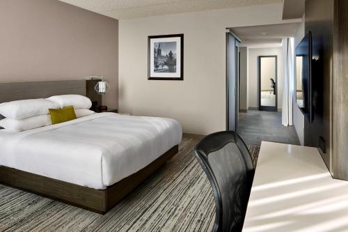 温莎Marriott Hartford/Windsor Airport的酒店客房配有一张床铺和一张桌子。