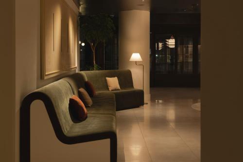 首尔Amid Hotel Seoul的带沙发和台灯的客厅