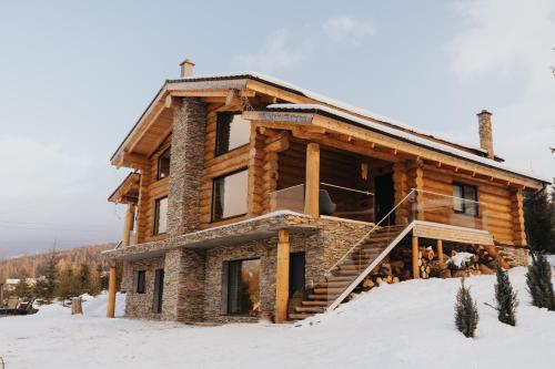 CozăneştiCABANA CEITREI - MOUNTAIN VIEW GIUMALAU的雪地中的小木屋,设有楼梯