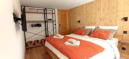 马格朗*Spacieux T3 Campagne proche lac*的一间卧室配有一张带橙色棉被的大床
