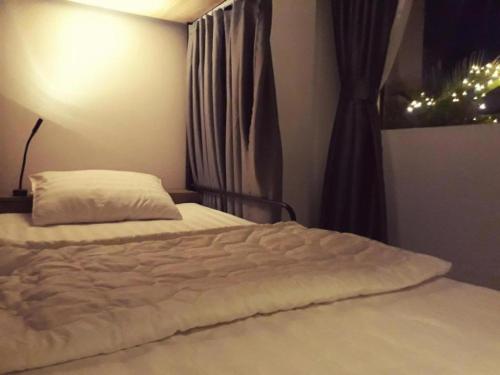 芹苴Adora Dorm Bed with Balcony in the Center的卧室内的一张白色床,设有窗户