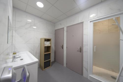 马赛Loft 250m2 avec écran led géant de 10m2的白色的浴室设有水槽和淋浴。
