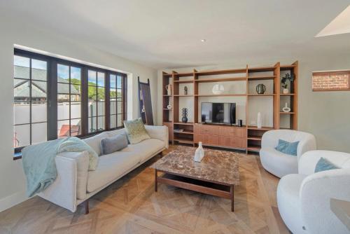 纳尔逊Monaco Poolside Apartment的客厅配有沙发、椅子和桌子