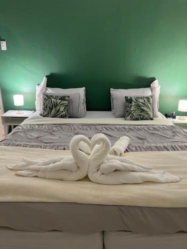 简蒂埃尔Villa Grand Jardin的床上有两条毛巾天鹅