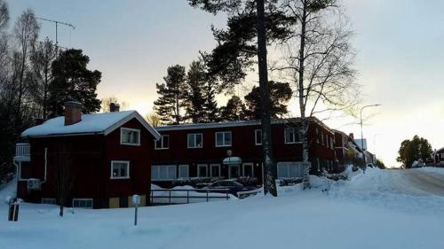 赖特维克Hostel Gästhem Glassen Apartment的一座大红房子,地面上积雪