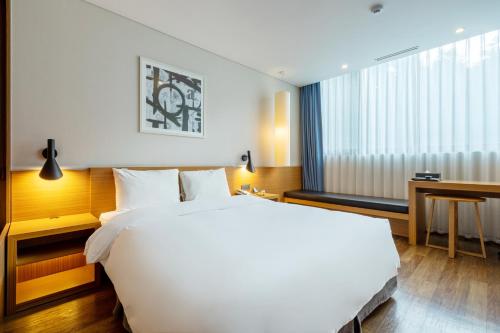 坡州市Mate Hotel Paju的卧室配有一张白色大床和一张书桌