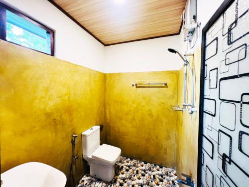 阿鲁特伽马Nature Bliss Villa的一间带卫生间和黄色墙壁的浴室
