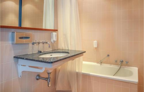 赫尔辛格H-504纳德斯特拉维公寓的浴室配有盥洗盆和浴缸。