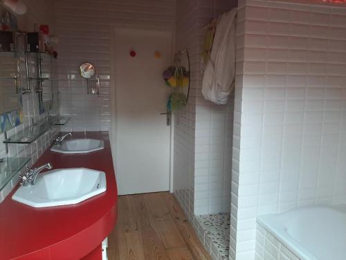 Verlhac-Tescouchambre deux personnes, lit pour Bébé的浴室设有两个盥洗盆和红色的柜台。